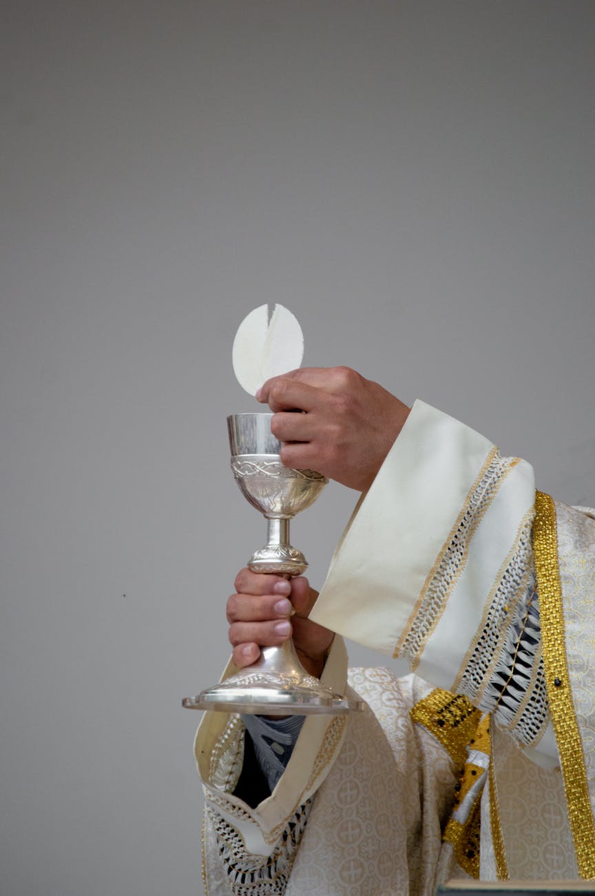 priest holding a chalice and communion bread